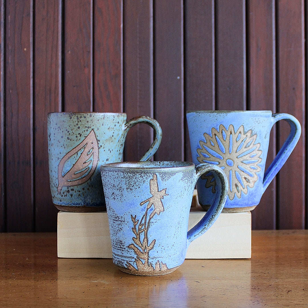 3 medium matte blue mugs in brown stoneware clay with stencil designs