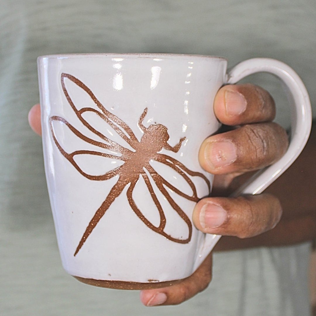 White mug with dragonfly stencil in hand