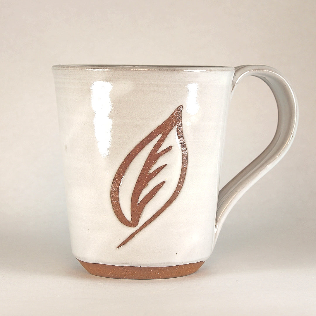 White ceramic mug with leaf stencil