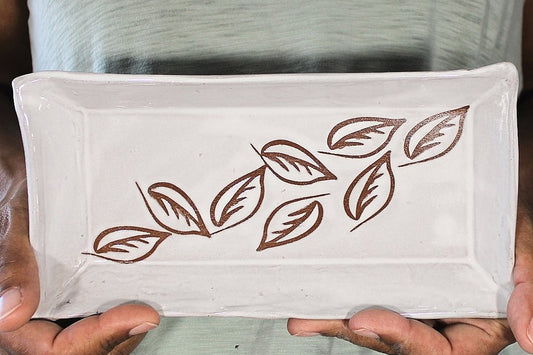 White ceramic tray with leaf stencils in hand